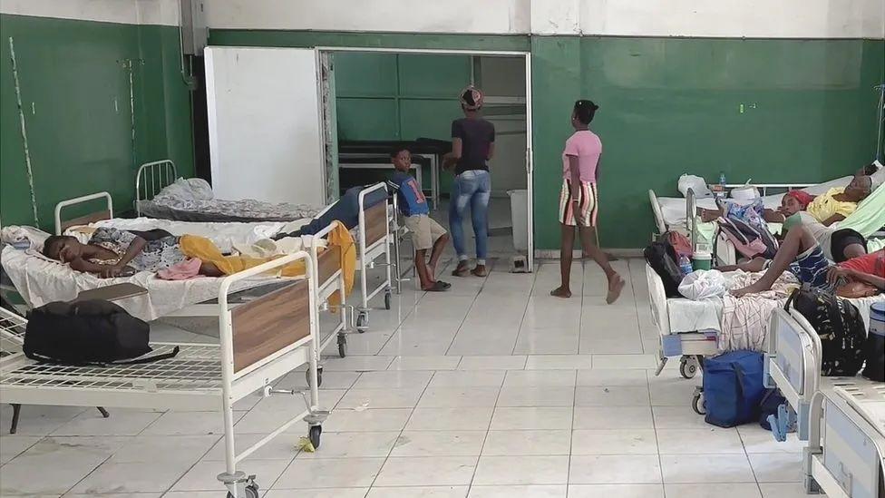 Sala de hospital com filas de camas com pacientes