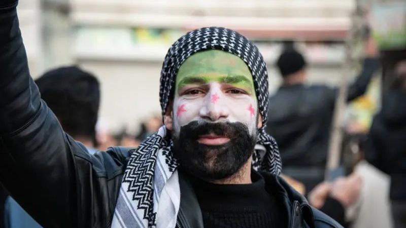 Seorang pengungsi Suriah dengan wajah yang dilukis dengan bendera Suriah di Ankara, Turki.