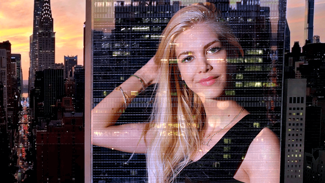 La fotografía de Kat Torres proyectada sobre un fondo estilizado de la ciudad de Nueva York.
