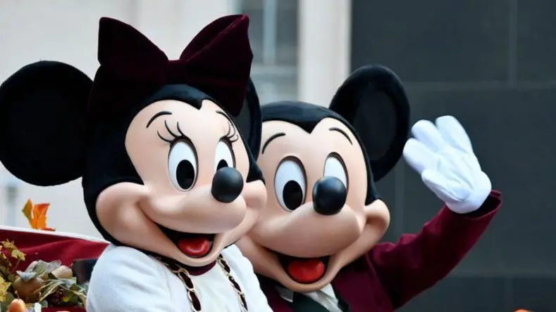 Personagens da Disney Mickey e Minnie acenando em parque da empresa