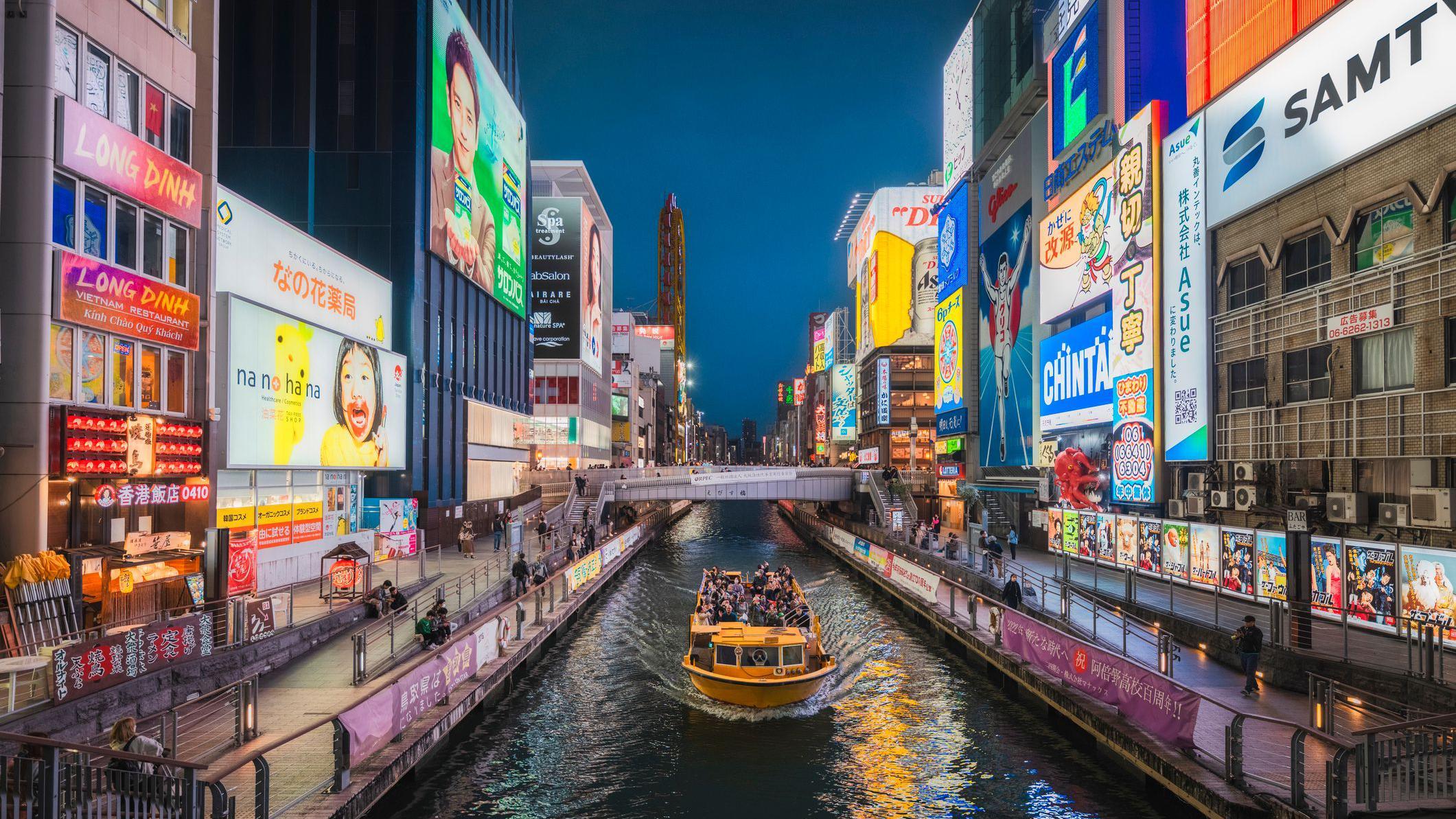 Barco em cidade cheia de neons