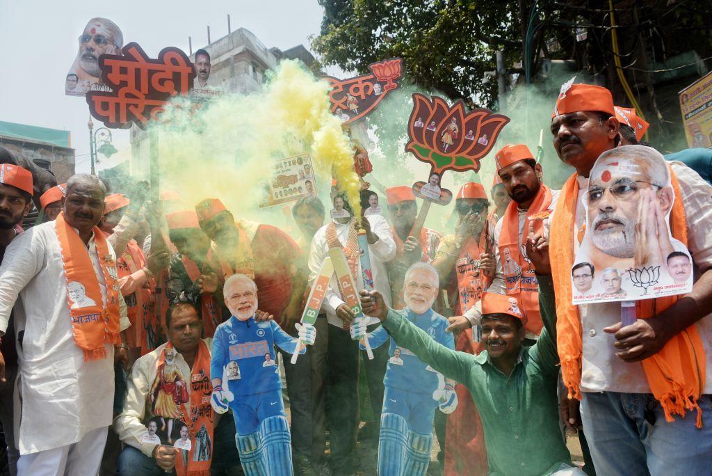 Apoiadores do BJP soltam bombas de fumaça e carregam um recorte do primeiro-ministro indiano Narendra Modi e gritam slogans para comemorar o dia do resultado da eleição de Lok Sabha em Varanasi