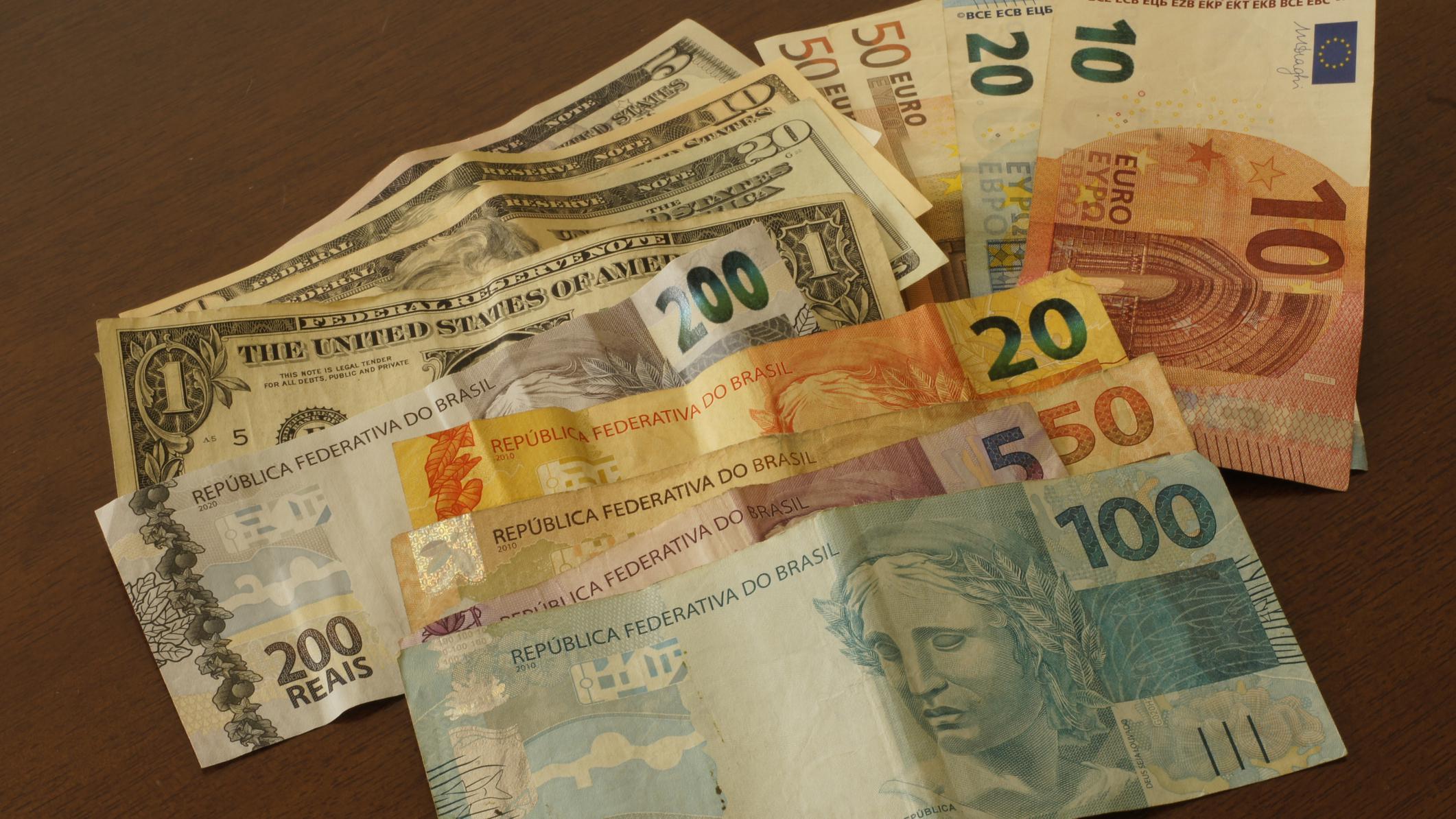 Notas de dólar, real e euro
