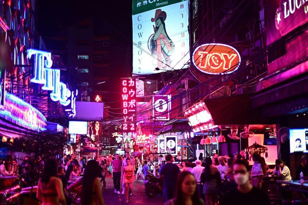 Visitantes caminando por la popular calle de entretenimiento nocturno conocida como "Soi Cowboy" en Bangkok.