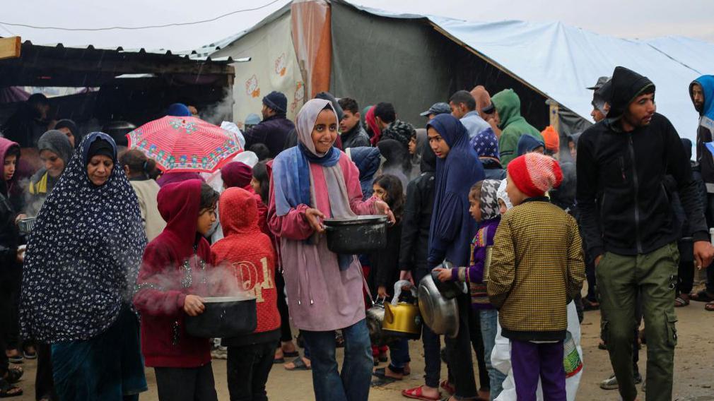 فلسطينيون يتلقون مساعدات غذائية