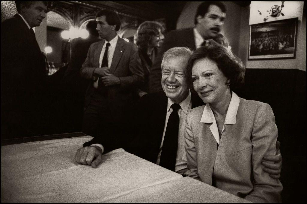 El matrimonio Carter sentado en una mesa y abrazados. 