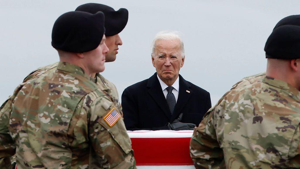 Joe Biden ante un féretro transportado por soldados.
