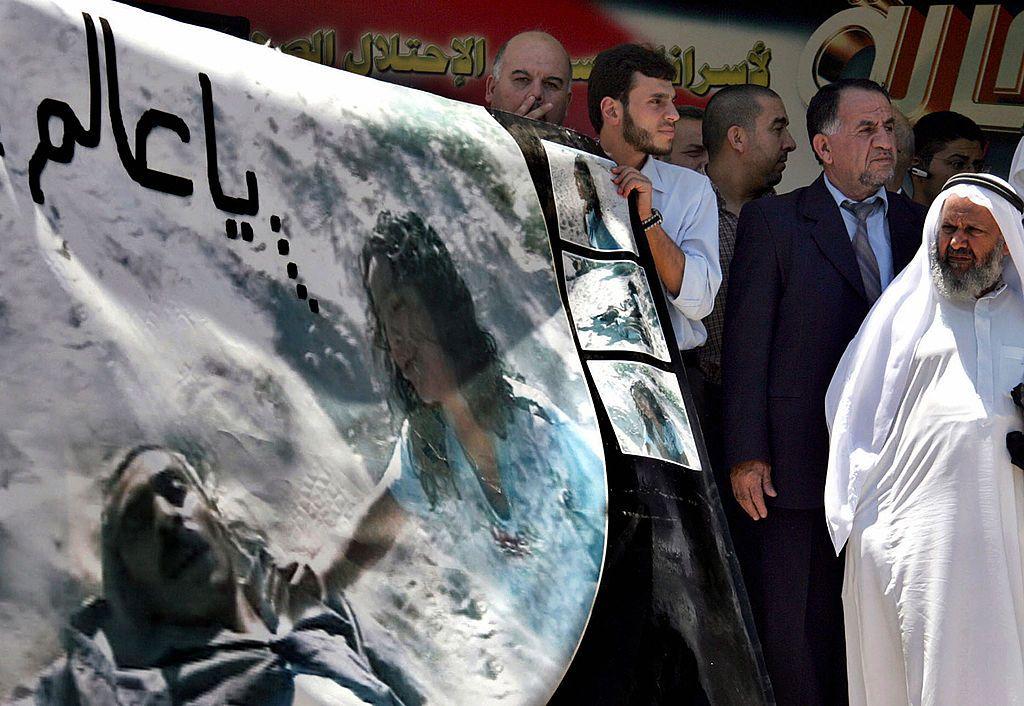 متظاهرون أردنيون يحملون ملصقاً للفتاة الفلسطينية هدى غالية التي قُتلت عائلتها في 9 يونيو/حزيران 2006، في غارة جوية إسرائيلية بينما كانوا يتنزهون على شاطئ غزة