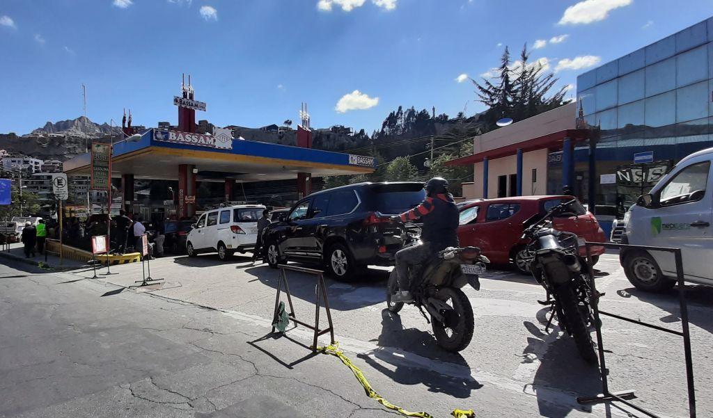Autos y motos hacen fila para repostar en una gasolinera boliviana