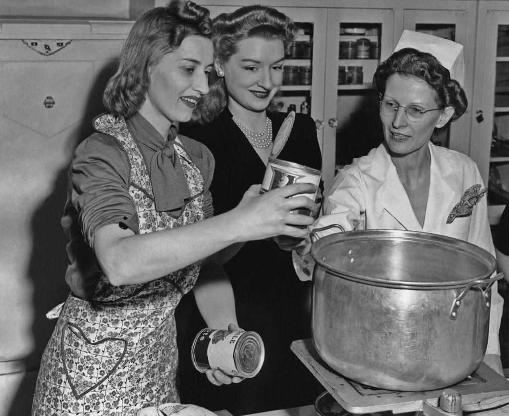 Tres mujeres cocinando con vegetales enlatados en torno al año 1940.