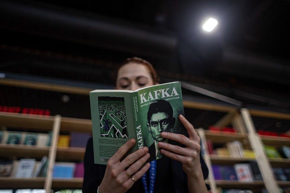 Una mujer leyendo un libro de Kafka