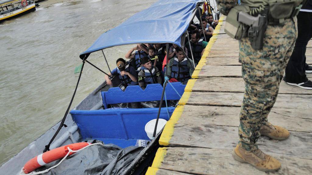 Lancha con migrantes en el muelle de Puerto Cartí, Panamá