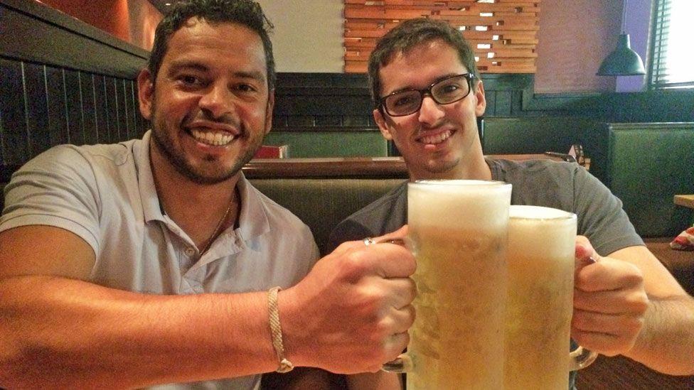 Daniel Guerra (esquerda) e Rodrigo Dantas (direita) brindando com duas canecas de cerveja em 2017