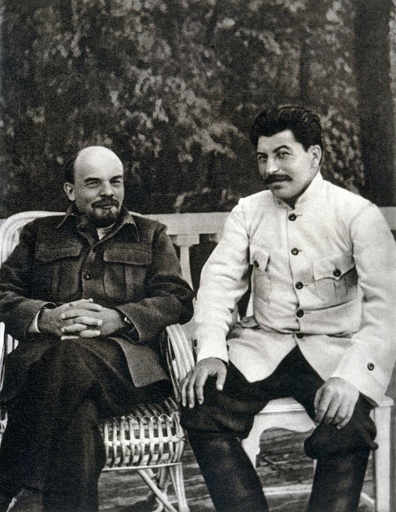 Lênin e Stalin sentados em um banco 