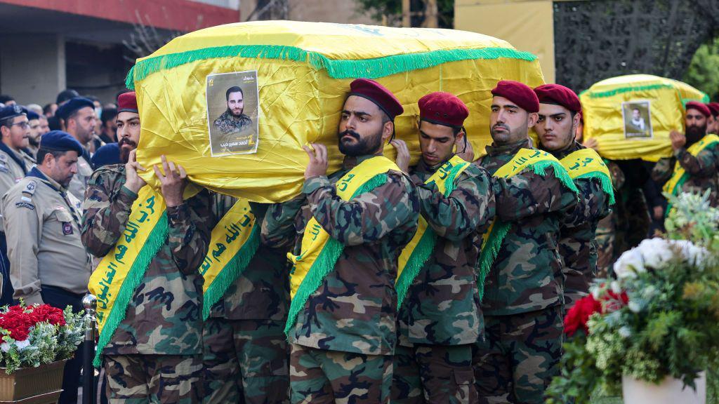 Membros do Hezbollah uniformizados carregando o caixão de um alto comandante do grupo