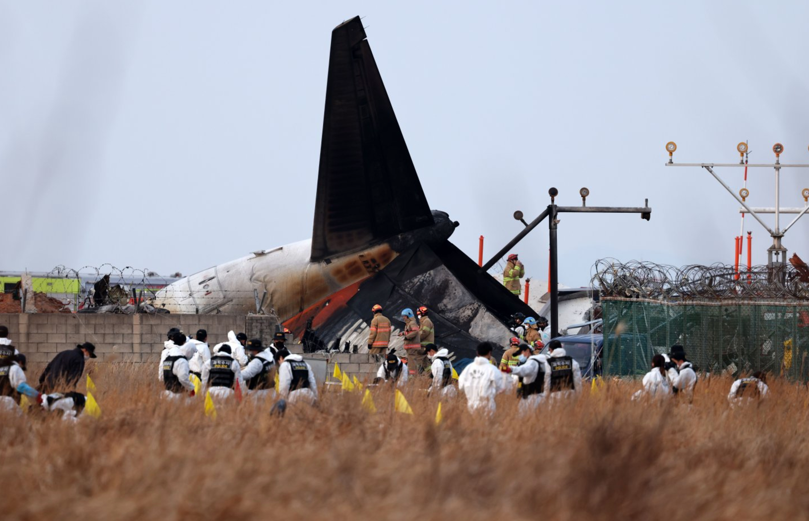 Petugas pemadam kebakaran dan petugas penyelamat bekerja di dekat lokasi jatuhnya pesawat Boeing 737-800 Jeju Air yang terbakar di Bandara Internasional Muan.