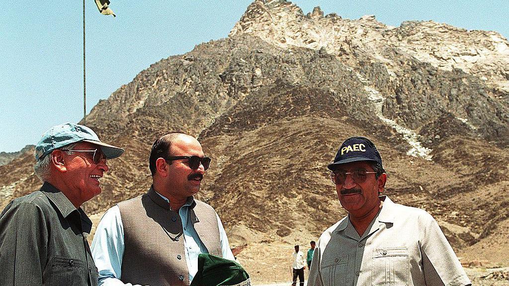 Dr. Samar Mubarak (R) and Dr. Ishfaq Ahmed (L), chairman of country's Atomic Energy Commission, stands in front of a hill under which Pakistan conducted its five nuclear tests
