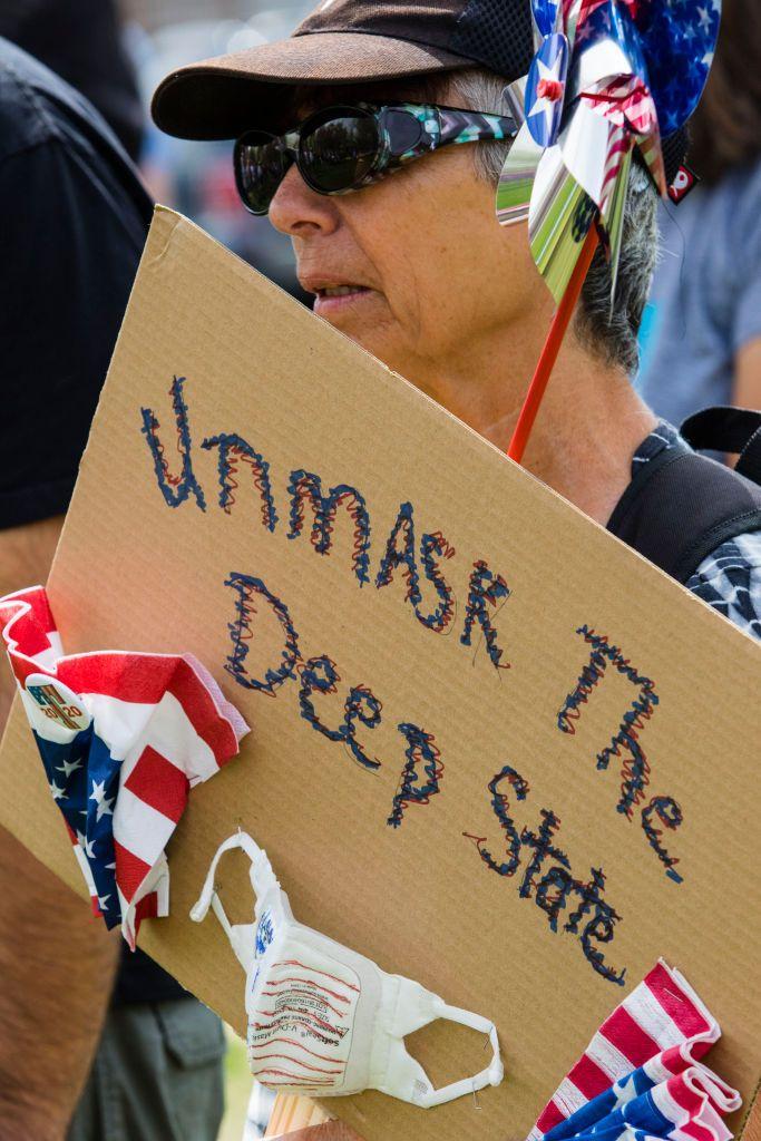 Una mujer en un mitin de Trump con una pancarta contra el Deep State.