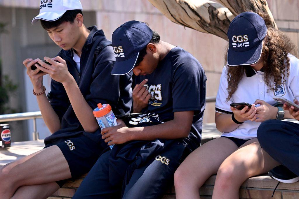 Jóvenes australianos mirando sus teléfonos inteligentes