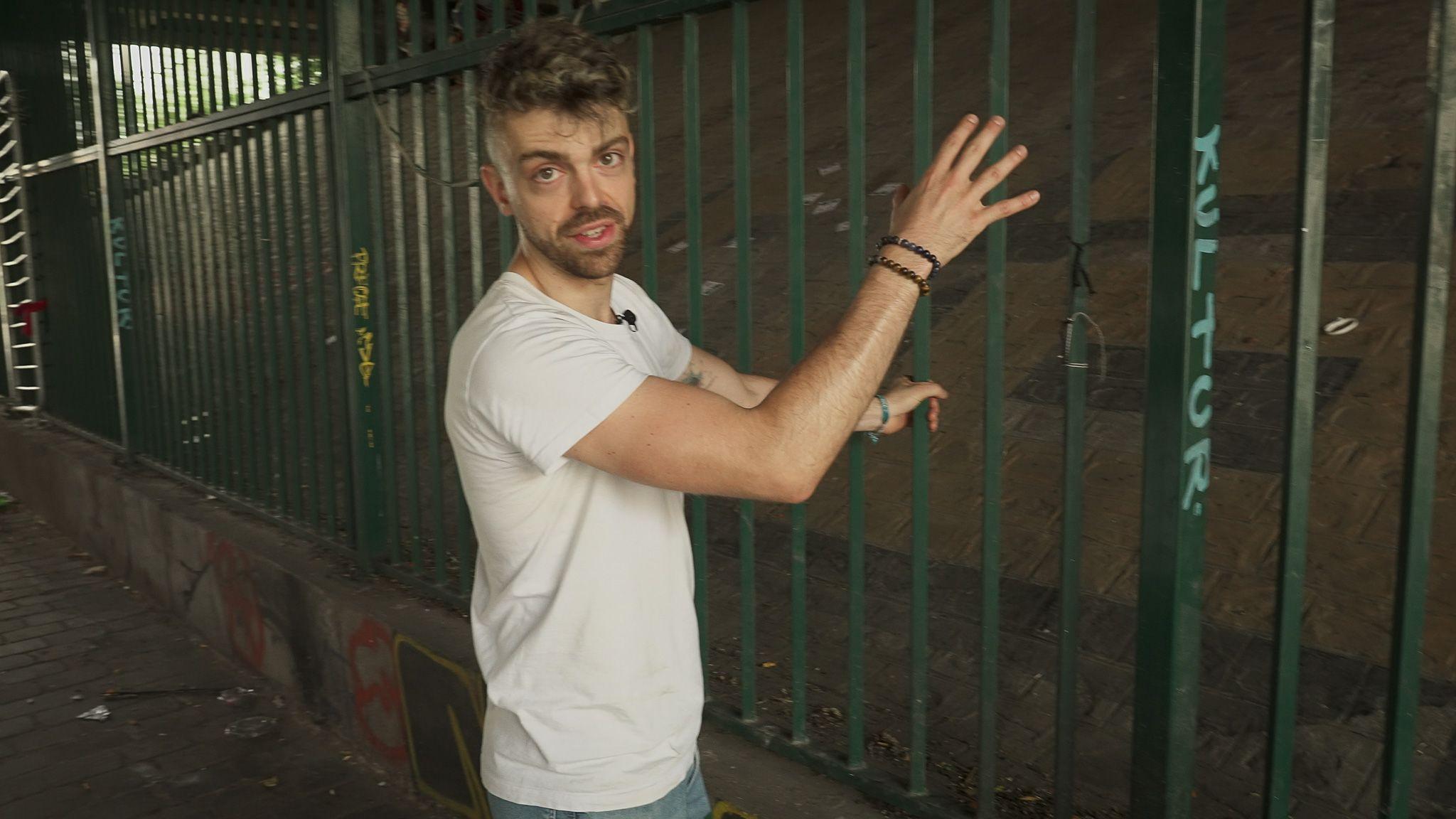 Paul Alauzy frente a una reja bajo un puente de París