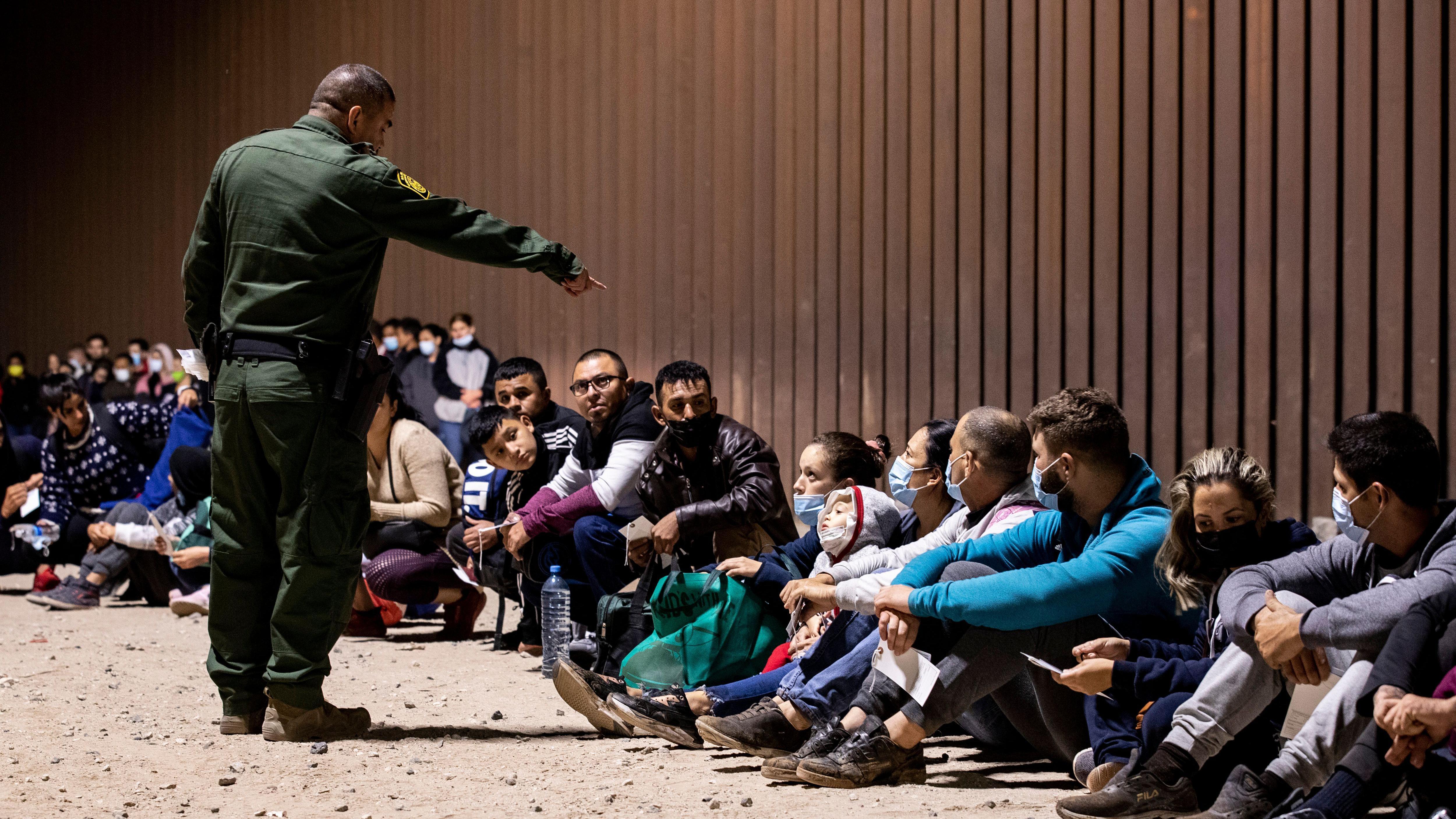 Un agente fronterizo frente a migrantes