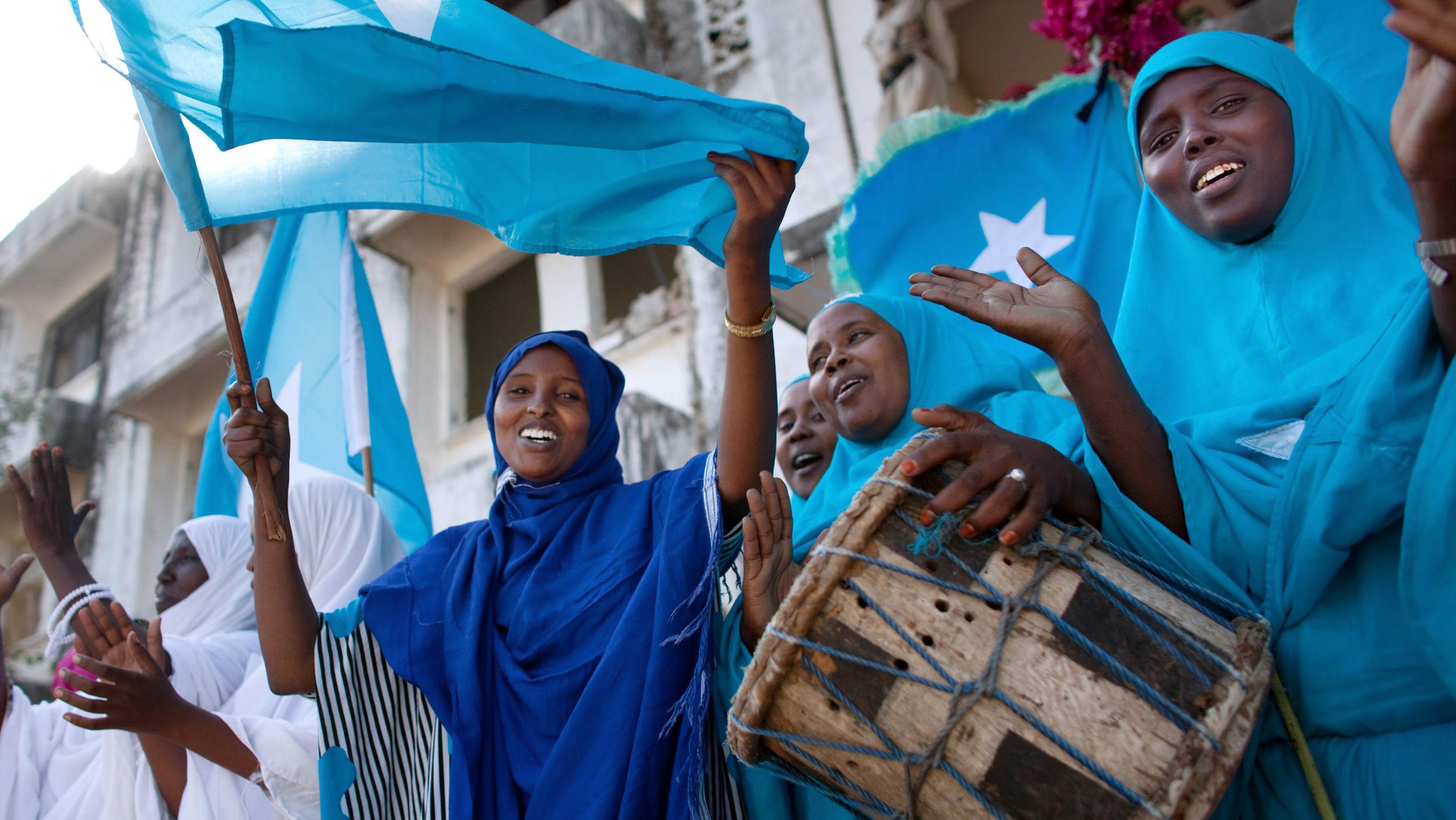 Mulheres somalis exibindo a bandeira do país durante uma cerimônia local