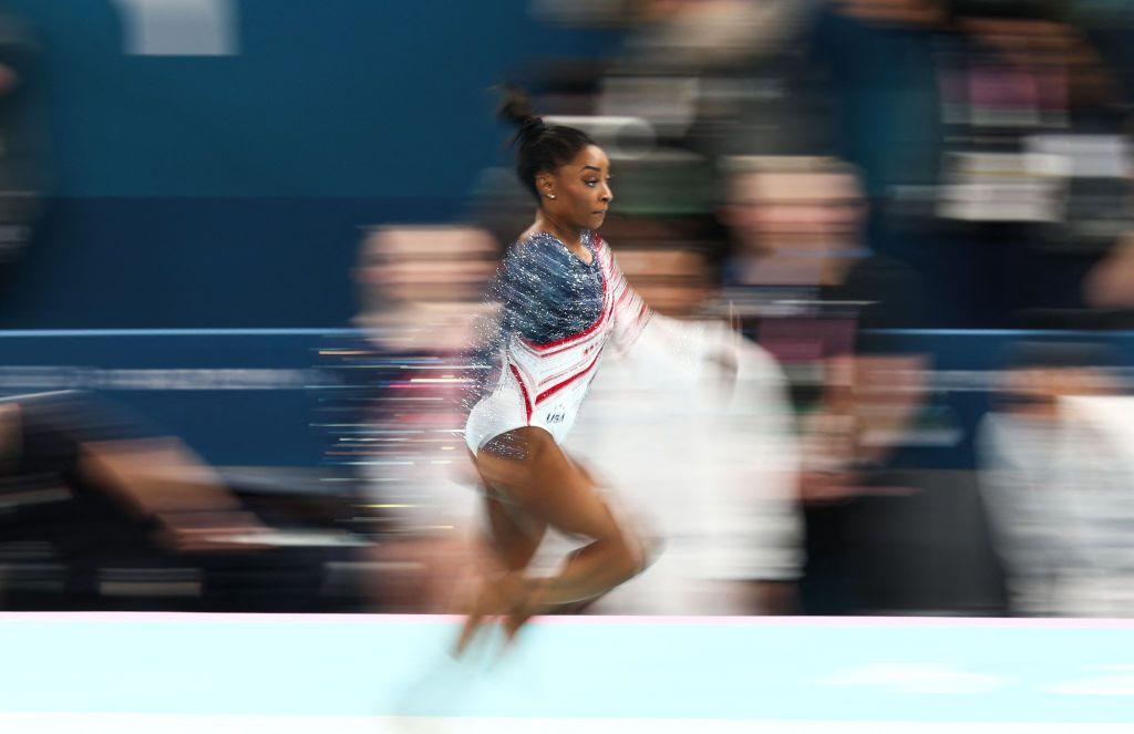 Simone Biles corriendo por una pista de gimnasia