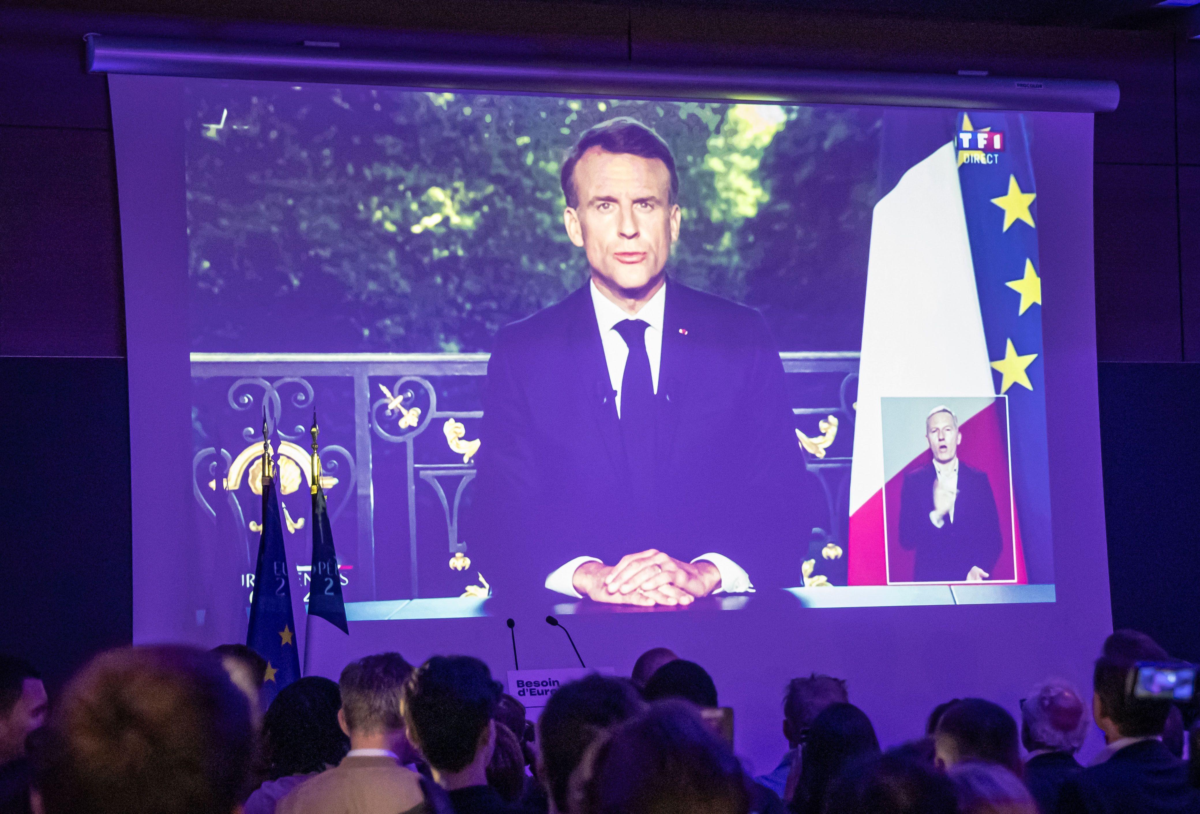 Una sala con seguidores de Macron lo ve en una pantalla dando el anuncio de elecciones anticipadas. 