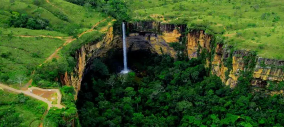 Cachoeira Véu da Noiva, na Chapada dos Guimarães, em meio a uma formação rochosa repleta de vegetação verde