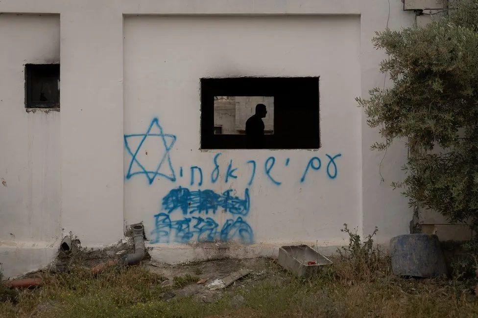 Grafite em uma casa palestina queimada na Cisjordânia diz “Israel viverá para sempre”