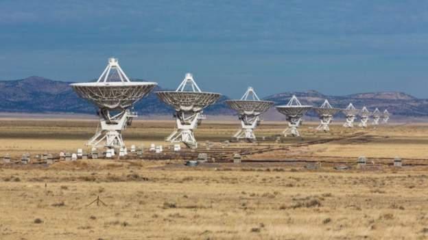 Fotografia colorida mostra antenas no chão do deserto apontadas para o céu