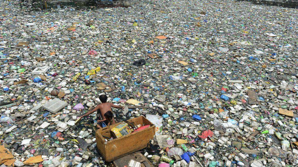 Pai e filho em meio a mar de lixo 
