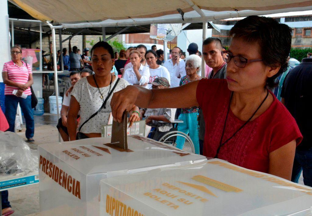 Una mujer deposita un voto en México