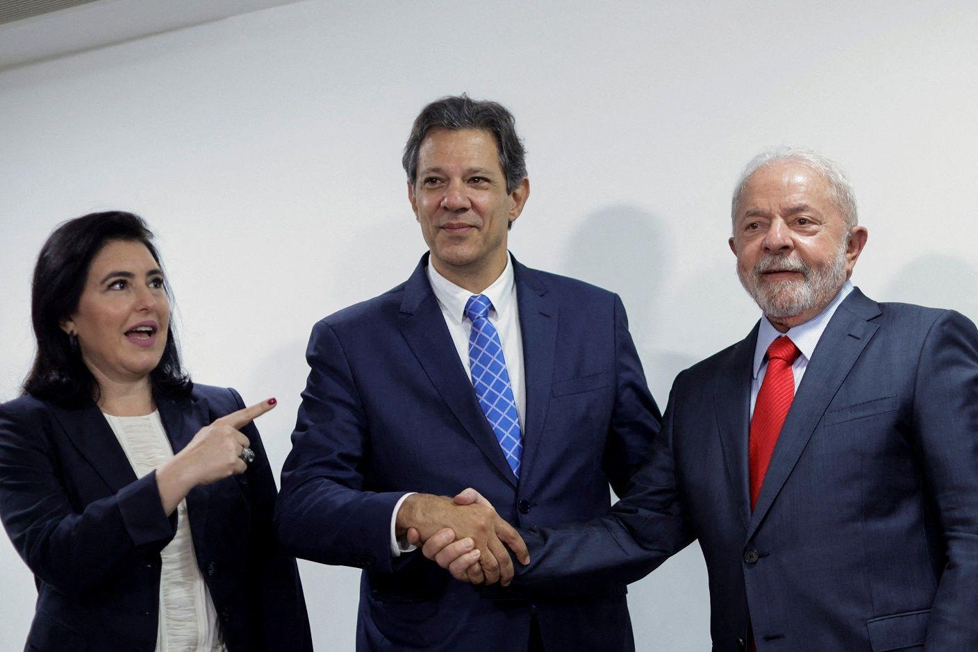 Tebet, Haddad e Lula posando para foto em frente a parede