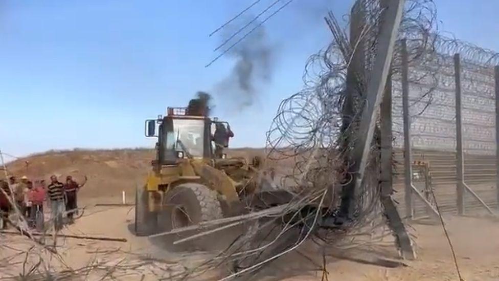 Una excavadora destruye un tramo de la barrera de Gaza.
