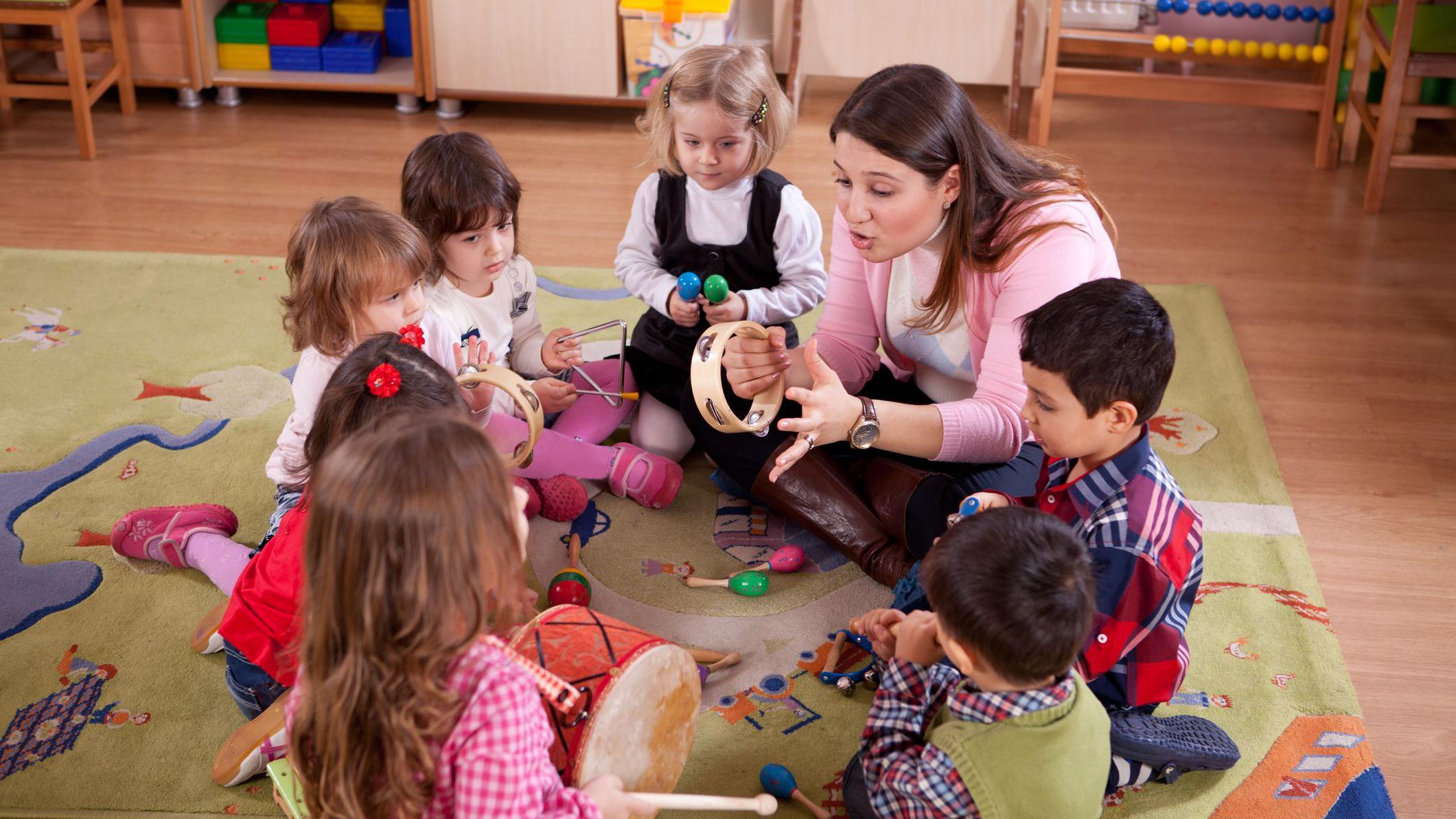 Niños y maestra en la sala de una guardería