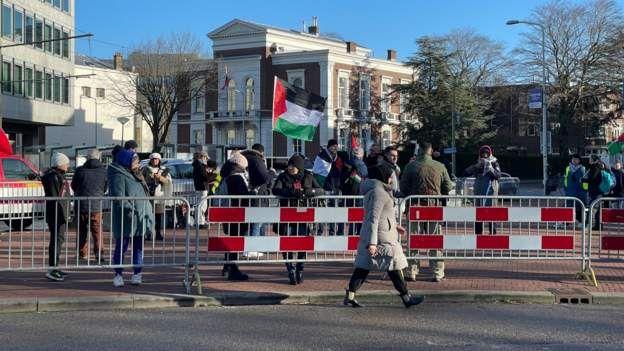 Pendukung Palestina berkumpul di depan Gedung Mahkamah Internasional sebelum pembacaan putusan terkait gugatan Afrika Selatan agar Israel menghentikan operasi militernya di Gaza