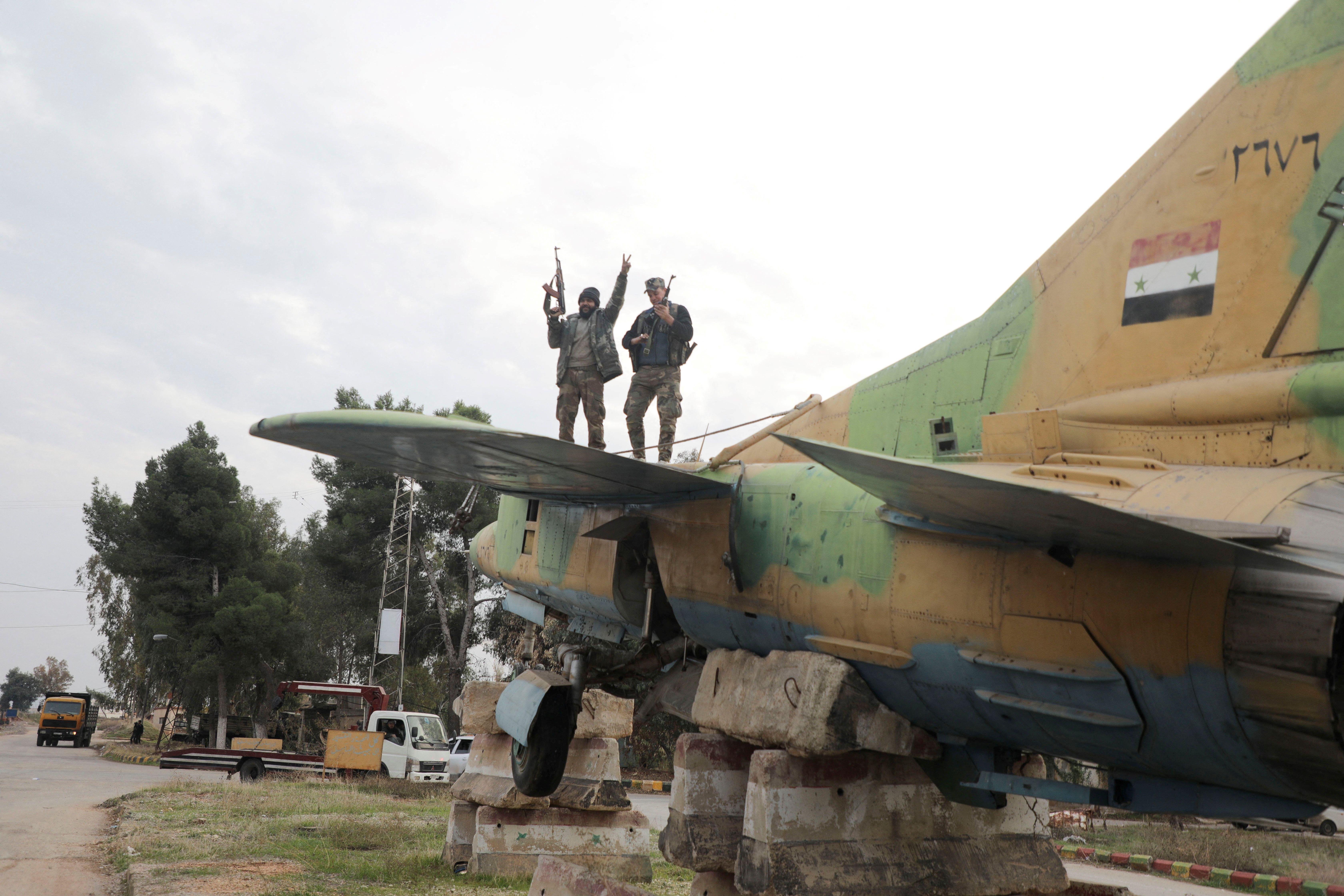 Rebeldes sobre un avión militar sirio.