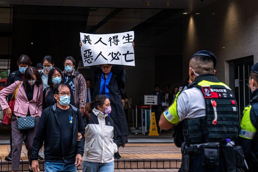 呂智恆養母Elsa在法庭外舉起印有「義人得生 惡人必亡」的標語（19/11/2024）