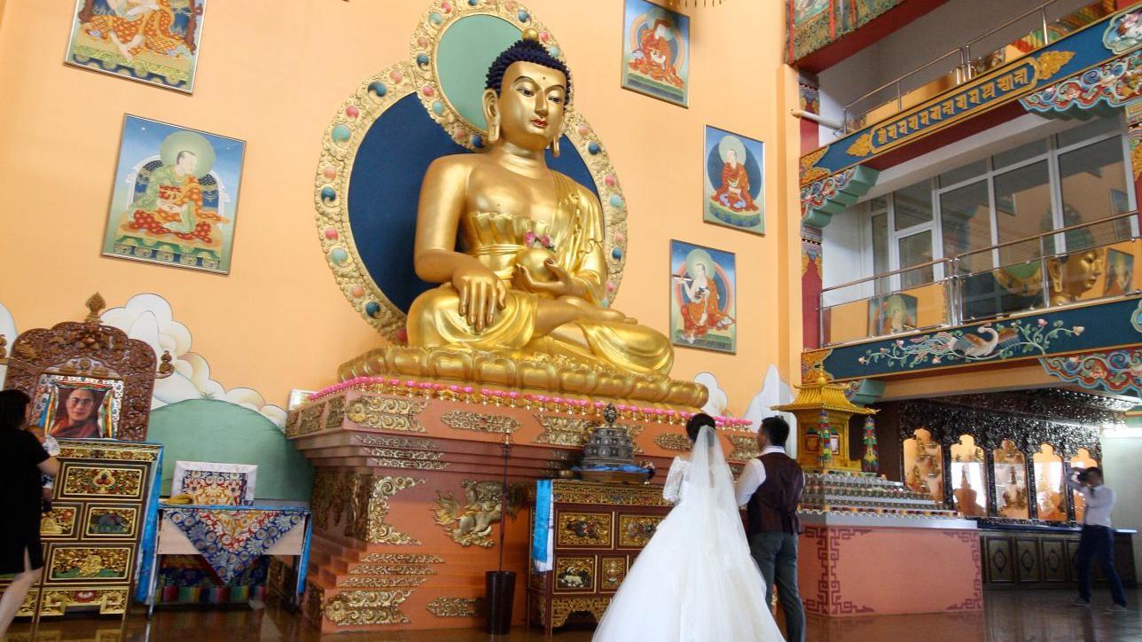 Casal de noivos em frente a estátua de Buda