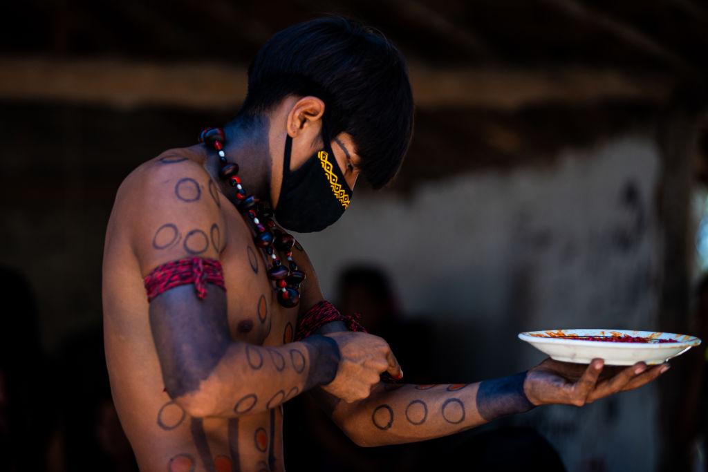 indígena Guarani se pinta para uma comemoração durante uma campanha de vacinação contra a Covid-19 na Aldeia Mata Verde Bonita (Tekoa Ka'Aguy Ovy Porã) em 20 de janeiro de 2021 em Marica (RJ), Brasil.