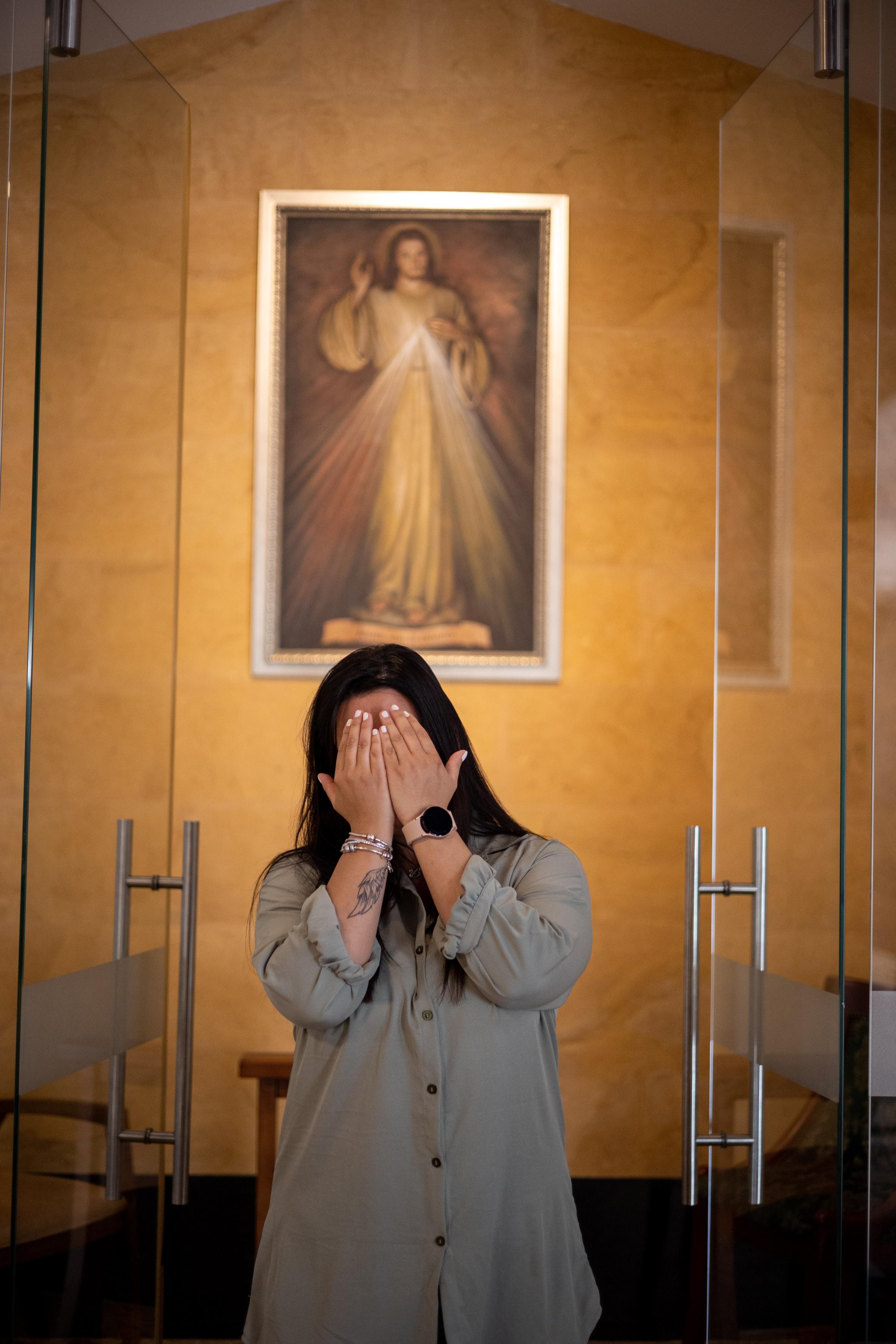Natalia Natalia en la parroquia Santa Gertrudis en Envigado, cubre su rostro con las manos para proteger su identidad