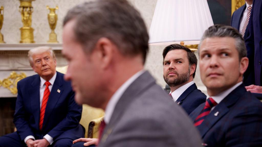 O presidente dos EUA, Donald Trump, o conselheiro de Segurança Nacional Michael Waltz, o vice-presidente J.D. Vance e o secretário de Defesa, Pete Hegseth, todos sentados, em uma entrevista coletiva no Salão Oval da Casa Branca