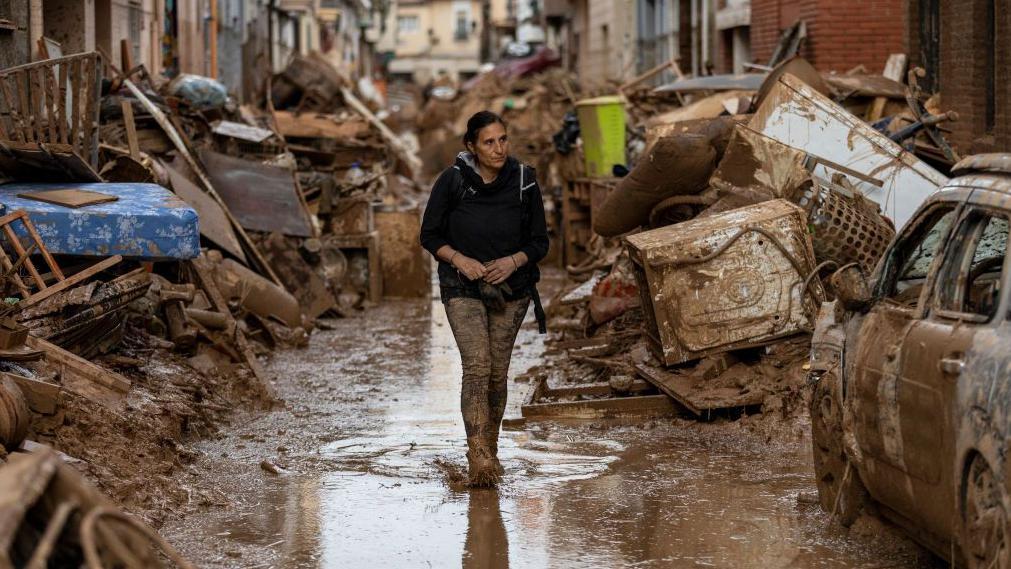 Una mujer camina en medio de la devastación en Valencia