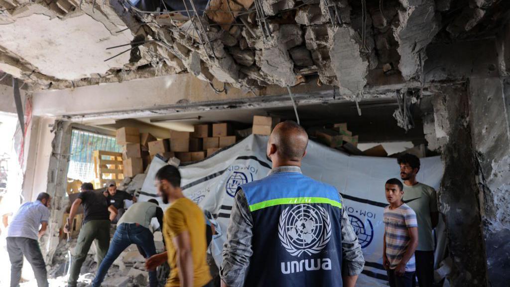 Trabajador de la Unrwa dentro de un edificio medio distruido