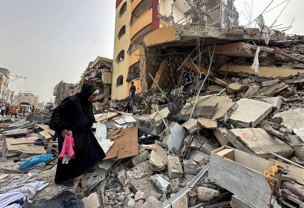 إمرأة تتفقد ركام بيتها في غزة 