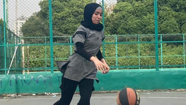 Una mujer con velo está jugando baloncesto. 