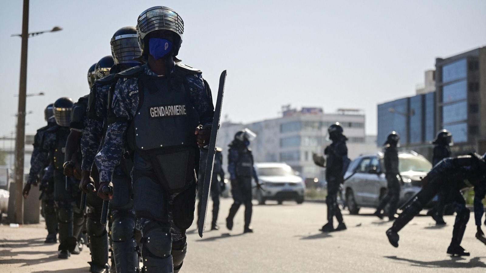 Militares caminham em confronto com manifestantes durante um protesto contra o adiamento das eleições presidenciais de 25 de fevereiro, em Dakar, Senegal