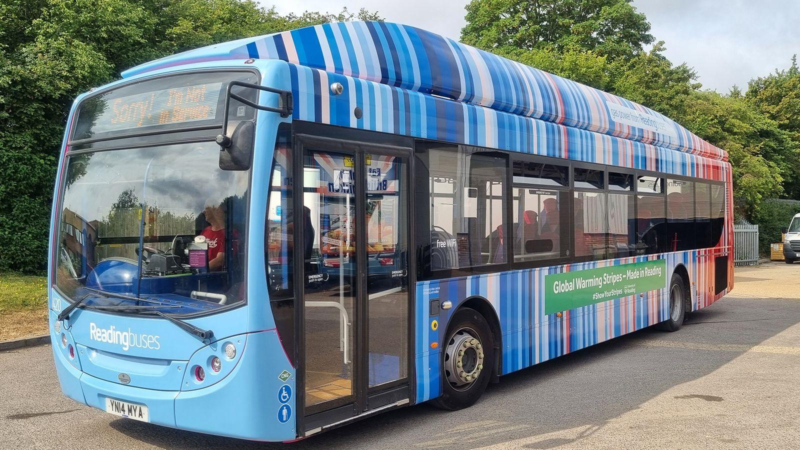 Autobús eléctrico en Reino Unido decorado con rayas de colores de azul a rojo.