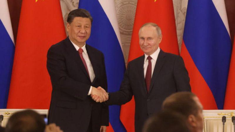 Xi Jinping e Vladimir Putin apertando as mãos